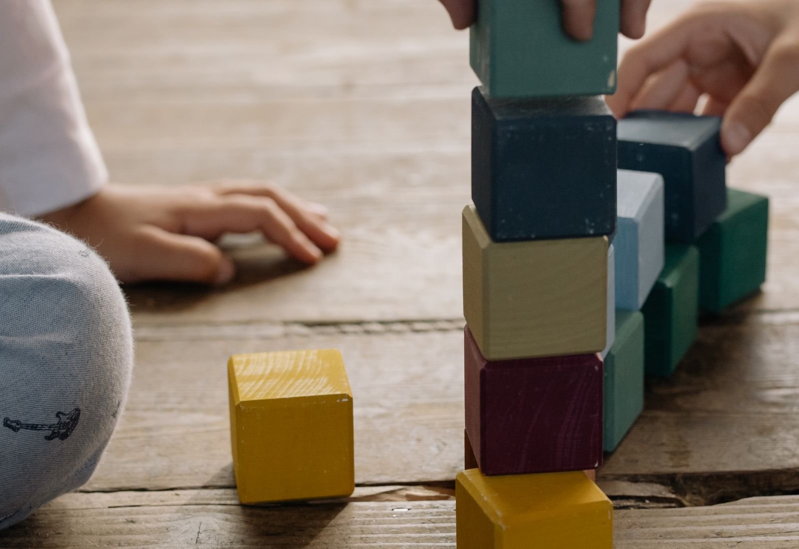 Children building with wooden blocks, practising fine motor skills